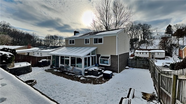 snow covered house with a sunroom