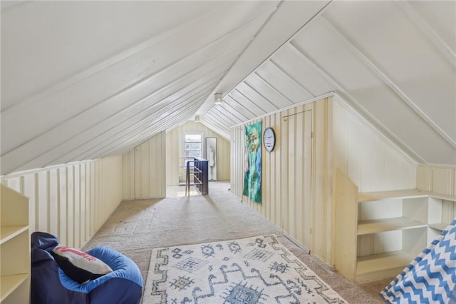 additional living space featuring vaulted ceiling and light colored carpet