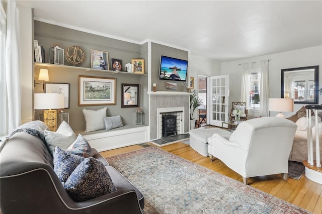 living room with a tiled fireplace and hardwood / wood-style flooring