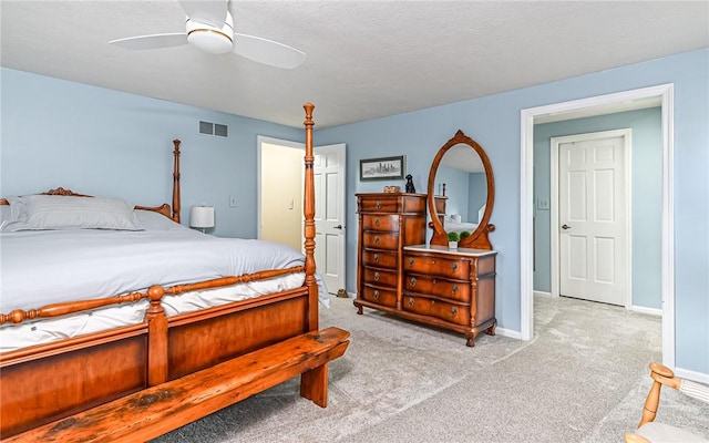 carpeted bedroom featuring ceiling fan and a textured ceiling