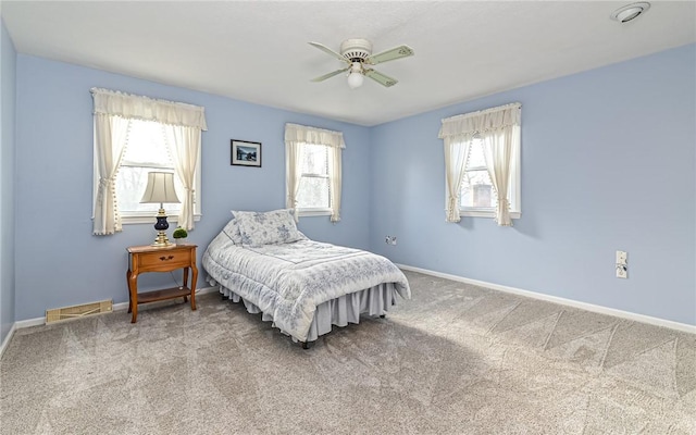 bedroom with ceiling fan, multiple windows, and carpet