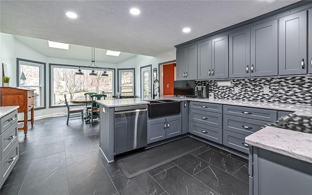 kitchen featuring hanging light fixtures, sink, gray cabinets, and stainless steel dishwasher