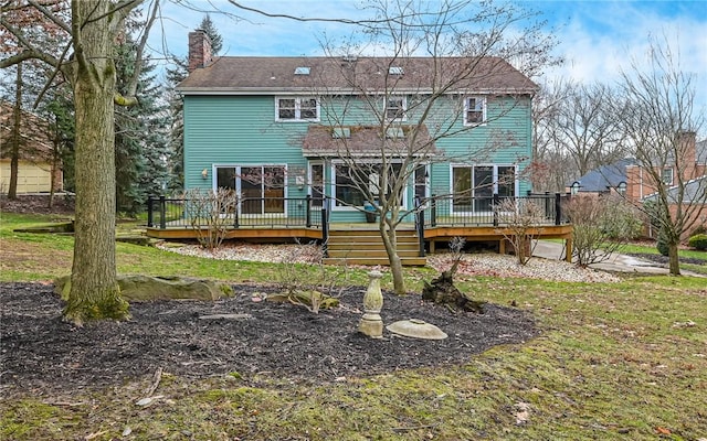 rear view of house featuring a yard and a deck