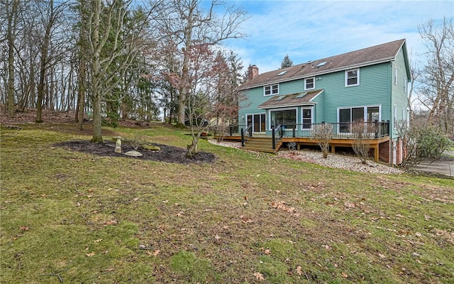 rear view of house with a yard and a deck