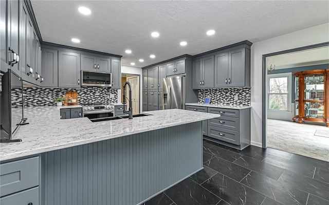 kitchen featuring stainless steel appliances, gray cabinets, and kitchen peninsula