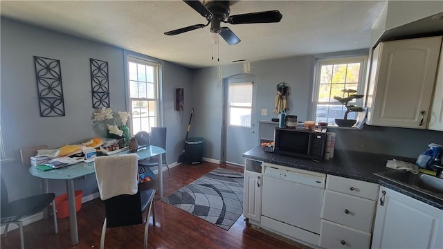 kitchen with sink, dishwasher, dark hardwood / wood-style floors, a healthy amount of sunlight, and white cabinets