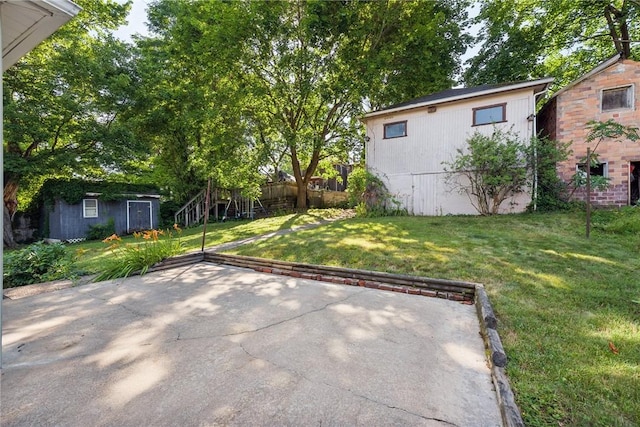 view of yard featuring a patio area and a storage unit