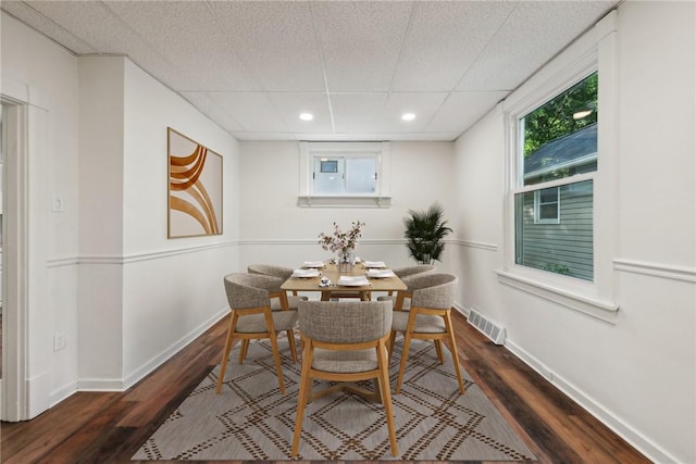 dining room featuring a paneled ceiling and dark hardwood / wood-style floors