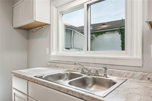 kitchen featuring white cabinetry and sink