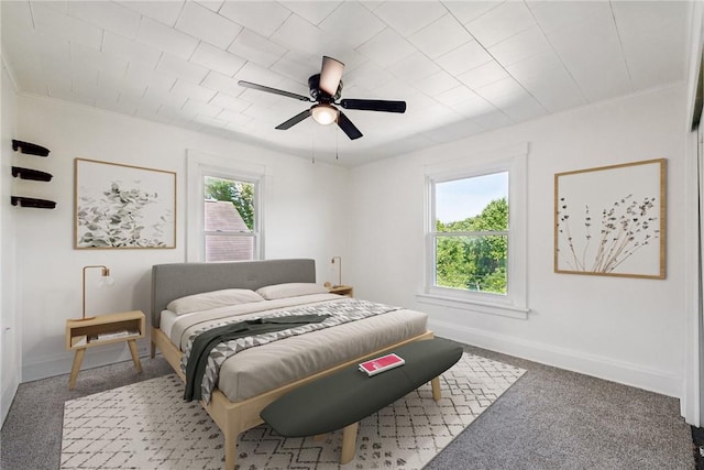 bedroom with ceiling fan, carpet flooring, and multiple windows