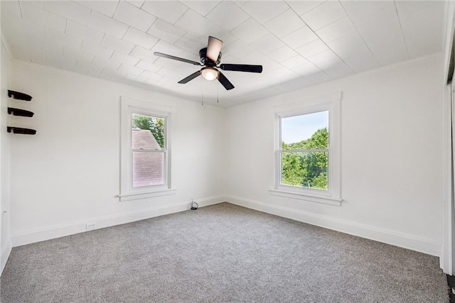 empty room with plenty of natural light, carpet floors, and ceiling fan