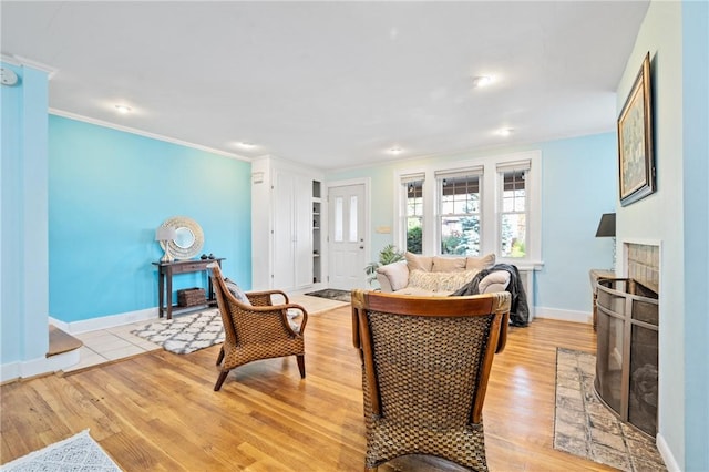 living room with ornamental molding, a fireplace, and light hardwood / wood-style floors