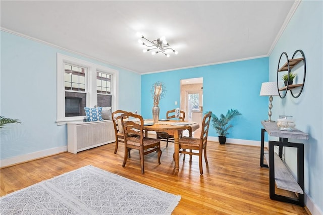 dining room with wood-type flooring, a chandelier, a wealth of natural light, and crown molding