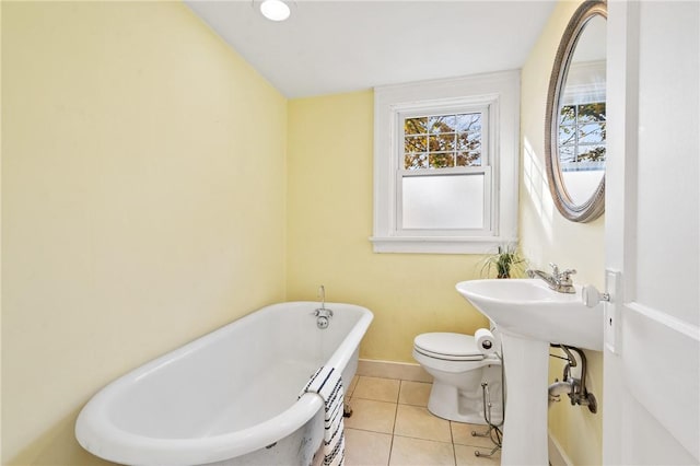 bathroom featuring a bath, tile patterned floors, and toilet