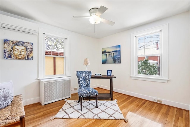 office space featuring ceiling fan, a wall mounted air conditioner, radiator, and hardwood / wood-style floors