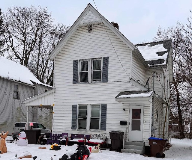 view of snow covered back of property