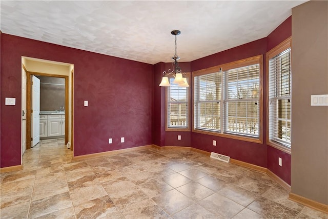 unfurnished dining area featuring an inviting chandelier