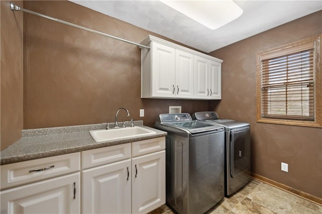 washroom featuring cabinets, sink, and washer and clothes dryer