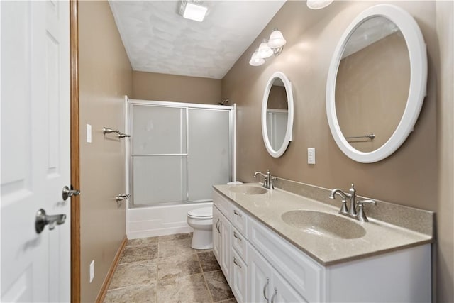 full bathroom with toilet, vanity, and shower / bath combination with glass door