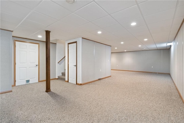 basement featuring light carpet and a drop ceiling