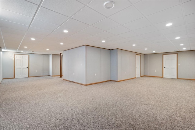 basement with carpet floors and a paneled ceiling