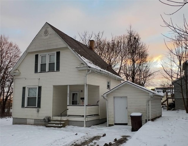 snow covered property with covered porch