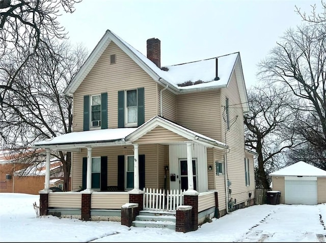 view of front of property featuring an outbuilding, a garage, and covered porch