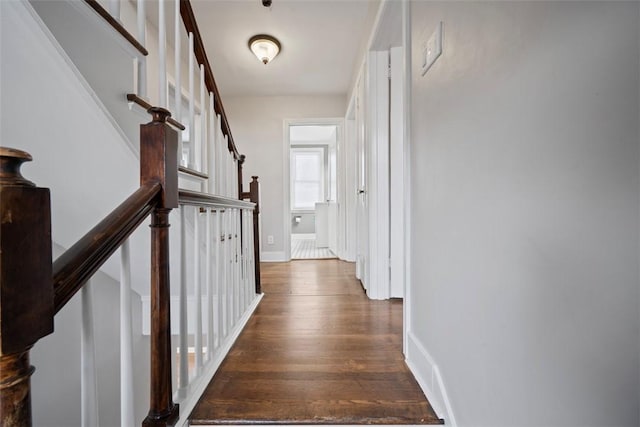 hallway featuring baseboards and wood finished floors