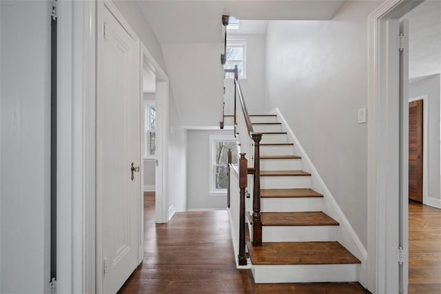 stairway with wood-type flooring and baseboards