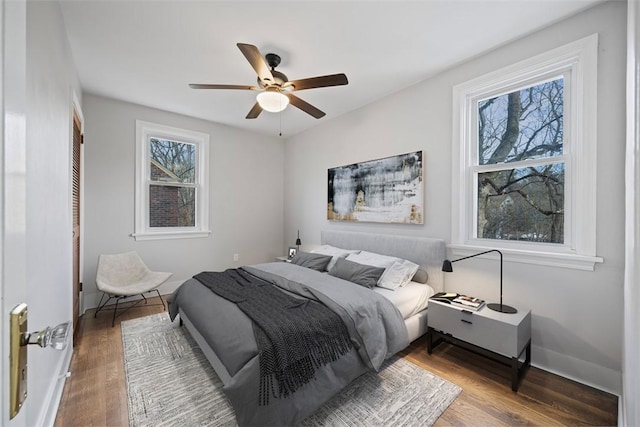 bedroom featuring wood finished floors, a ceiling fan, and baseboards