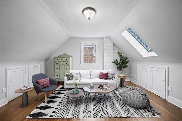 interior space with lofted ceiling, baseboards, visible vents, and wood finished floors