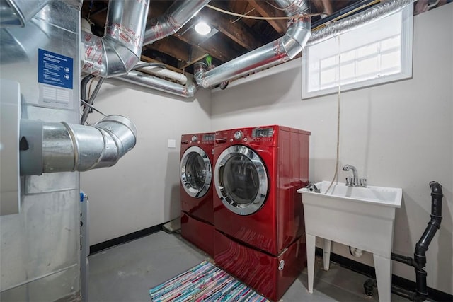 laundry area featuring independent washer and dryer, a sink, and baseboards