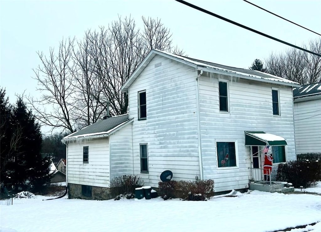 view of snow covered back of property