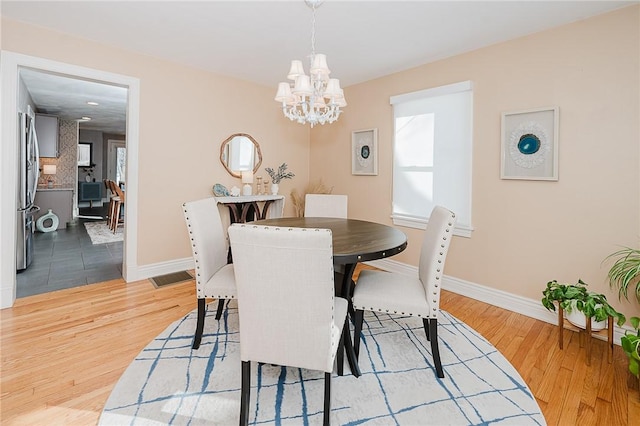 dining space with a chandelier and light wood-type flooring