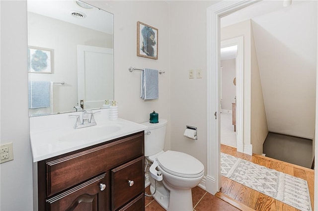 bathroom with vanity, hardwood / wood-style floors, and toilet