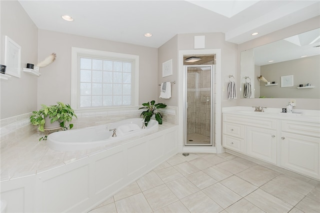 bathroom featuring vanity, plus walk in shower, a skylight, and tile patterned flooring