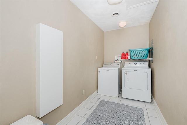 clothes washing area with separate washer and dryer and light tile patterned floors