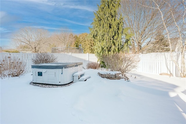 snowy yard with a hot tub