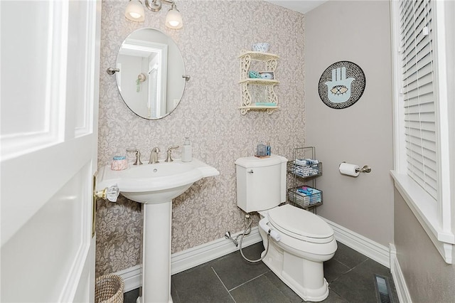 bathroom with sink, toilet, and tile patterned flooring