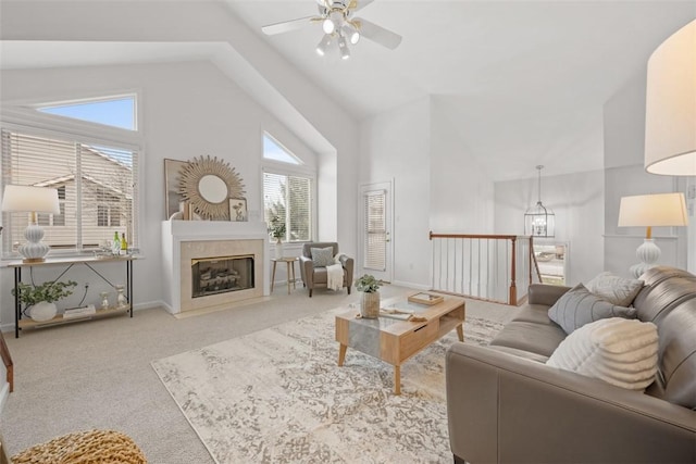 living room featuring ceiling fan, high vaulted ceiling, carpet floors, and a high end fireplace