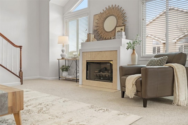 living area with a tiled fireplace and carpet flooring