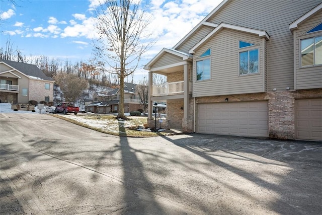 view of side of home with a garage and a balcony