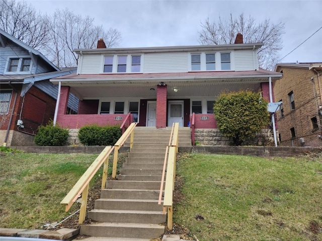 view of front facade featuring a front yard and covered porch