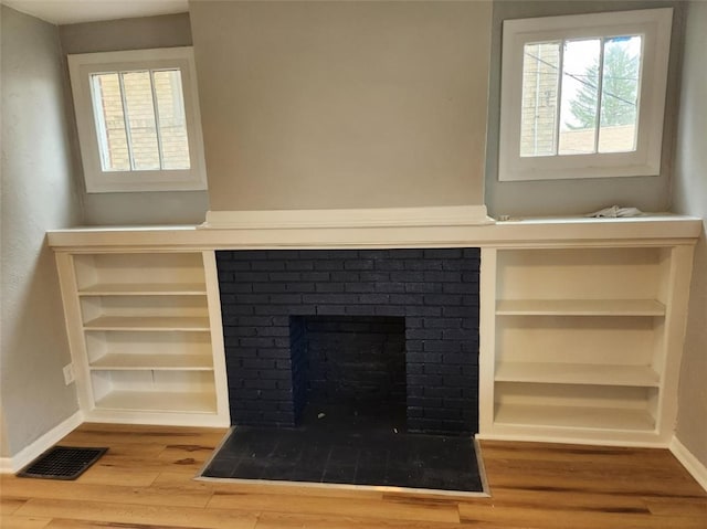 interior details with hardwood / wood-style floors and a brick fireplace