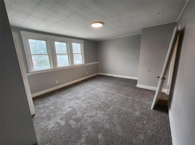 carpeted spare room featuring crown molding