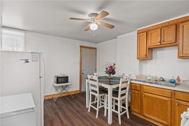 kitchen featuring white refrigerator, ceiling fan, sink, and dark hardwood / wood-style flooring