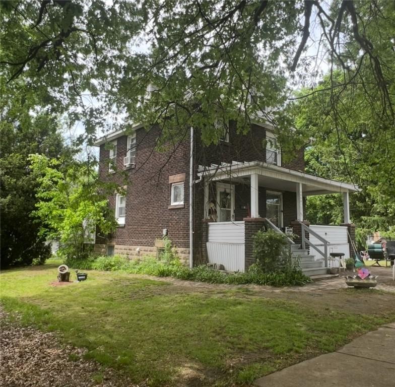 1008 Baldwin Ave, Sharon, PA 16146 - view of home's exterior featuring a lawn, covered porch, brick siding, and cooling unit