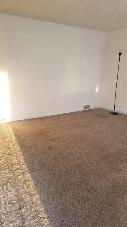 unfurnished room with dark colored carpet