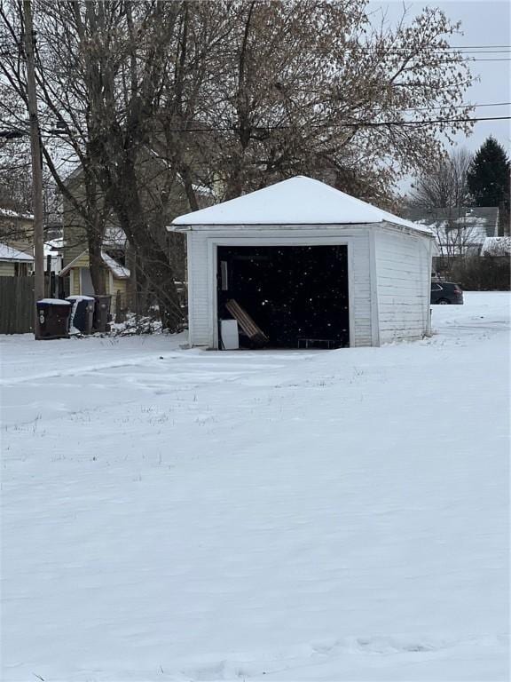 snow covered structure with a garage