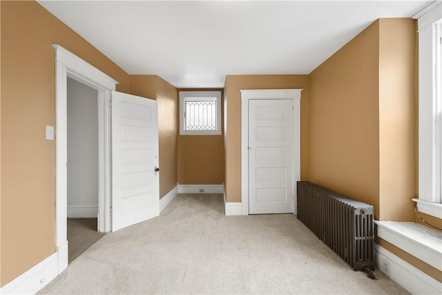 bedroom with radiator and light carpet